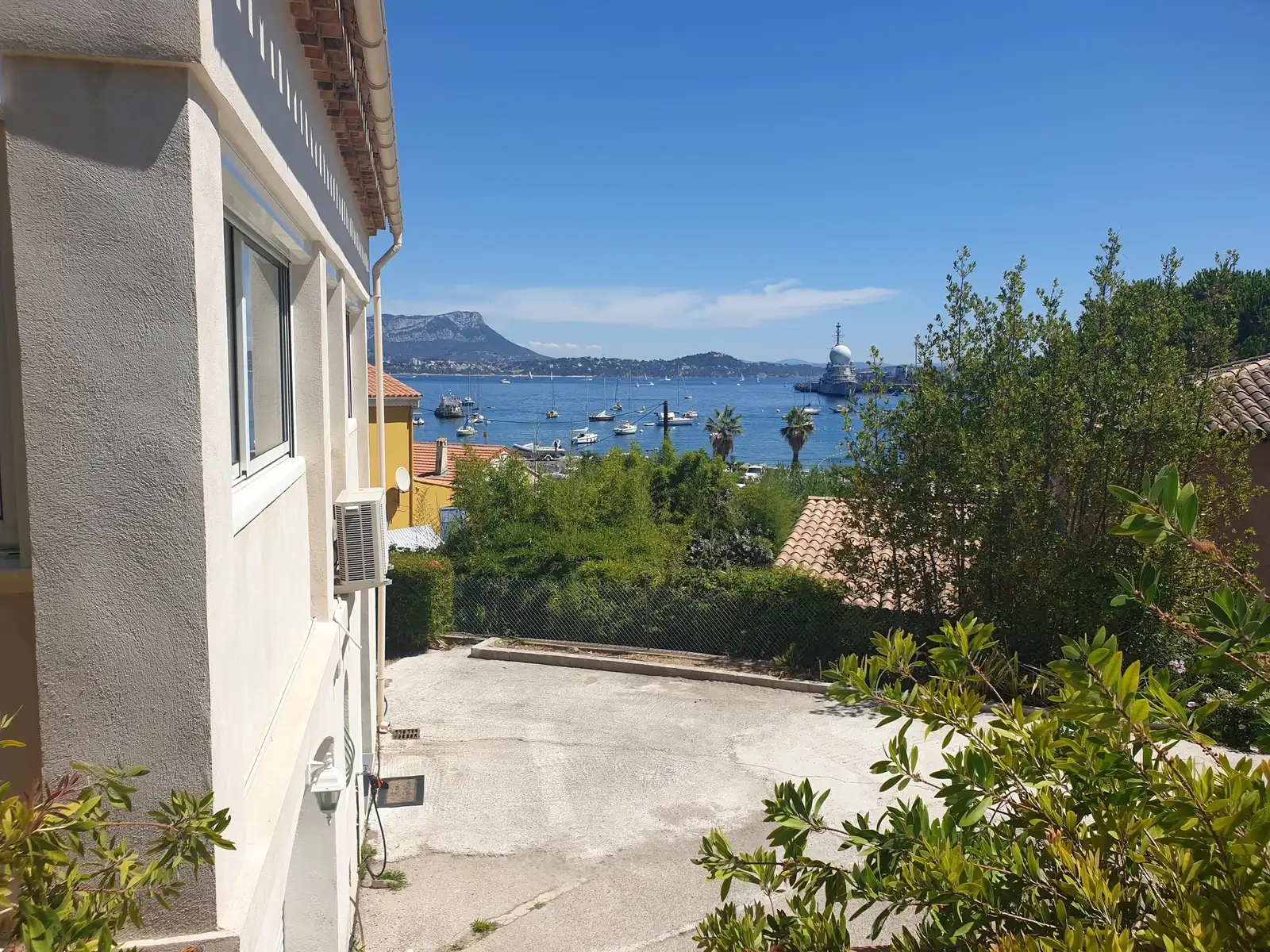 Cour d’accès et stationnement, avec la mer en arrière-plan