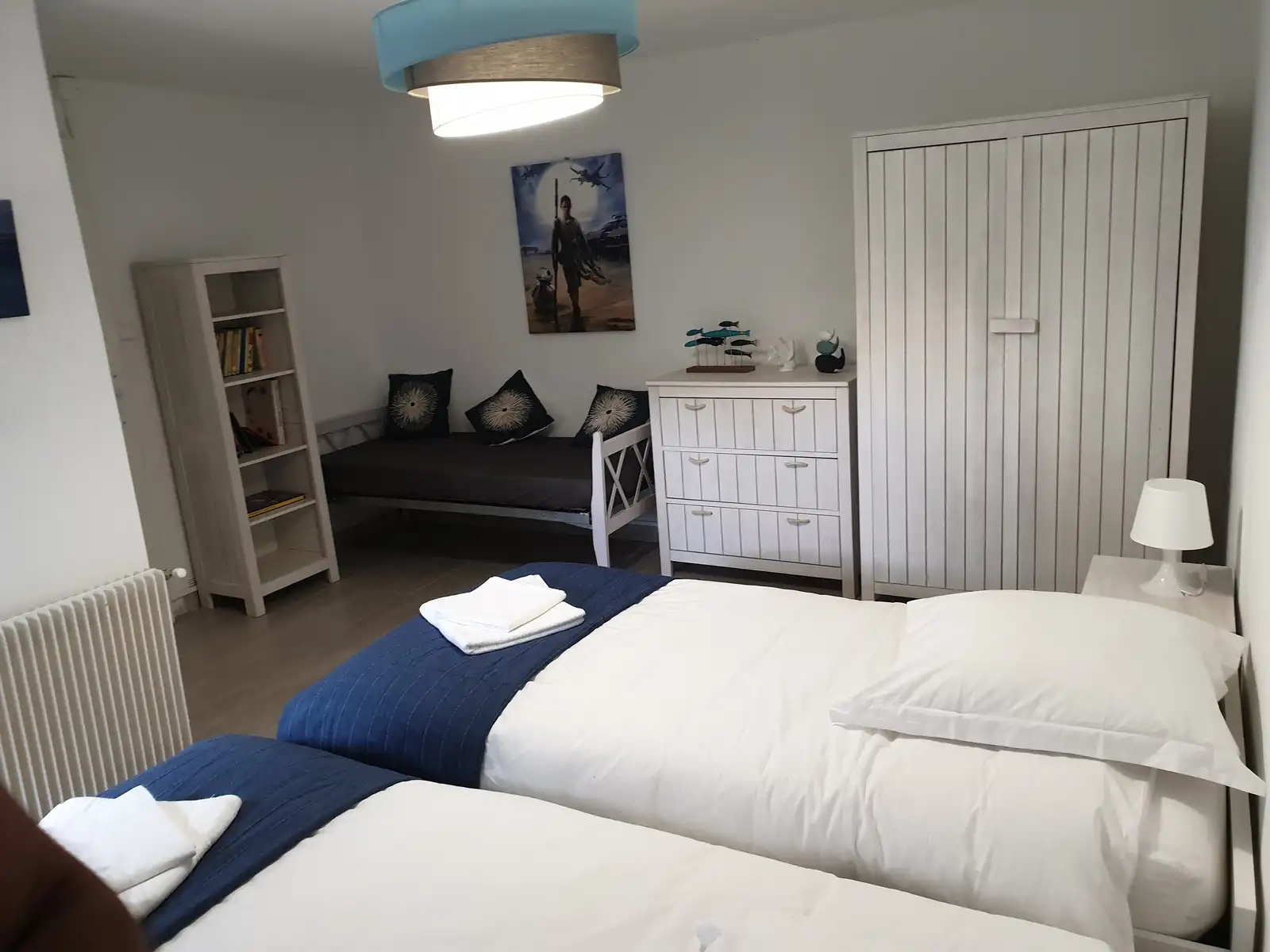 Chambre avec deux lits simples et armoire