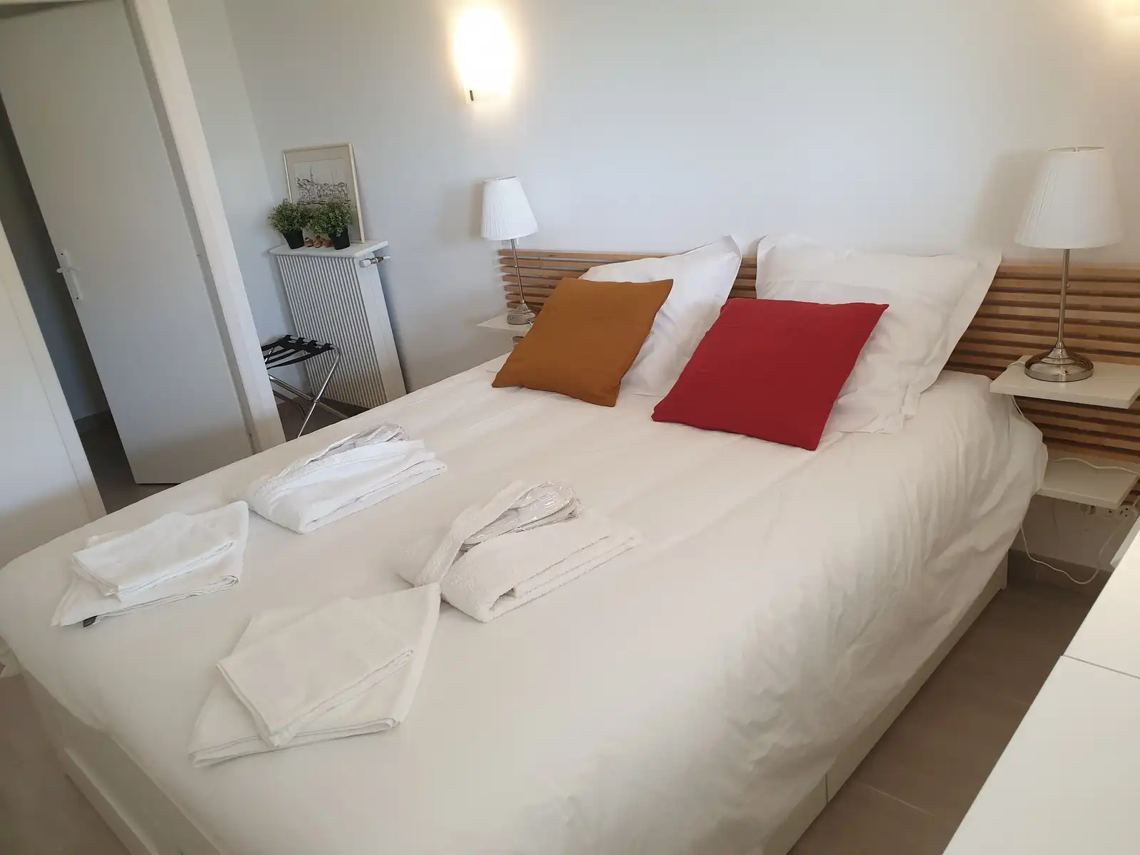 Chambre avec grand lit, lampes de chevet et linge fourni