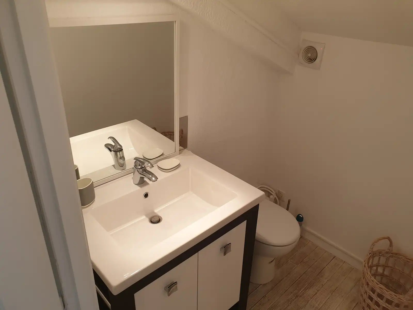 Salle d’eau sous plafond incliné, avec lavabo et toilettes
