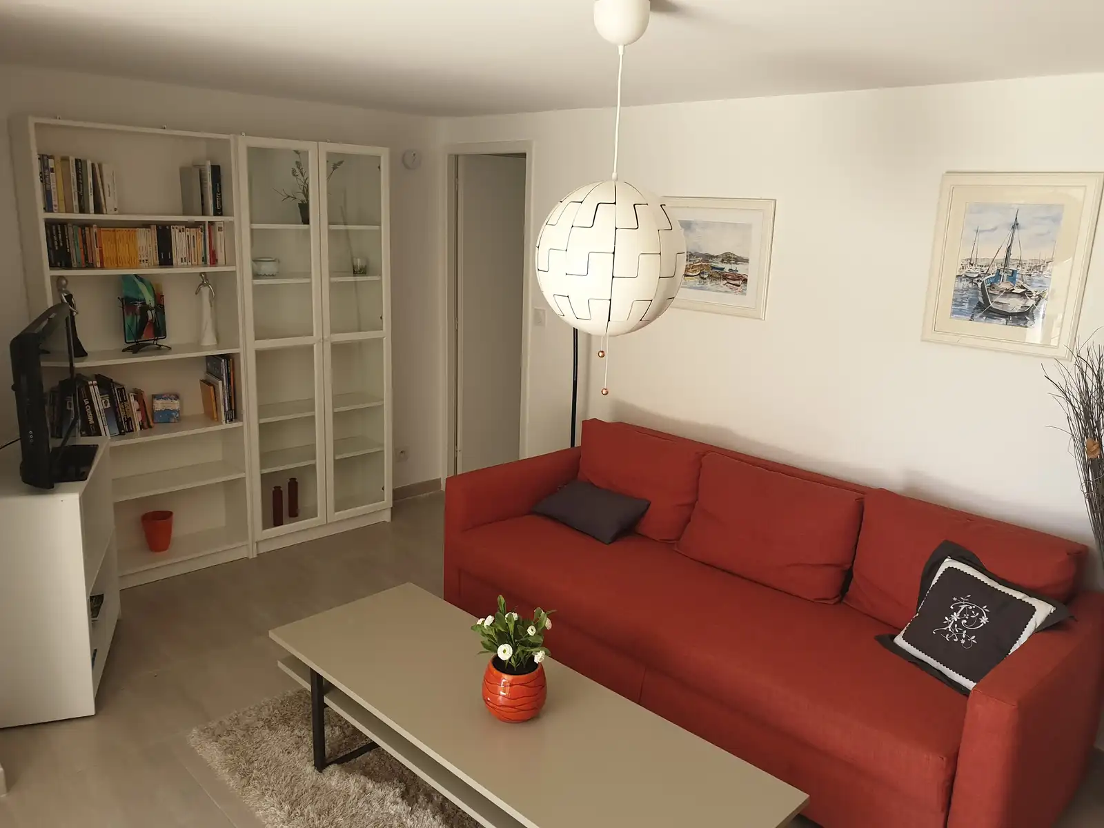 Second salon avec canapé, bibliothèque et télévision